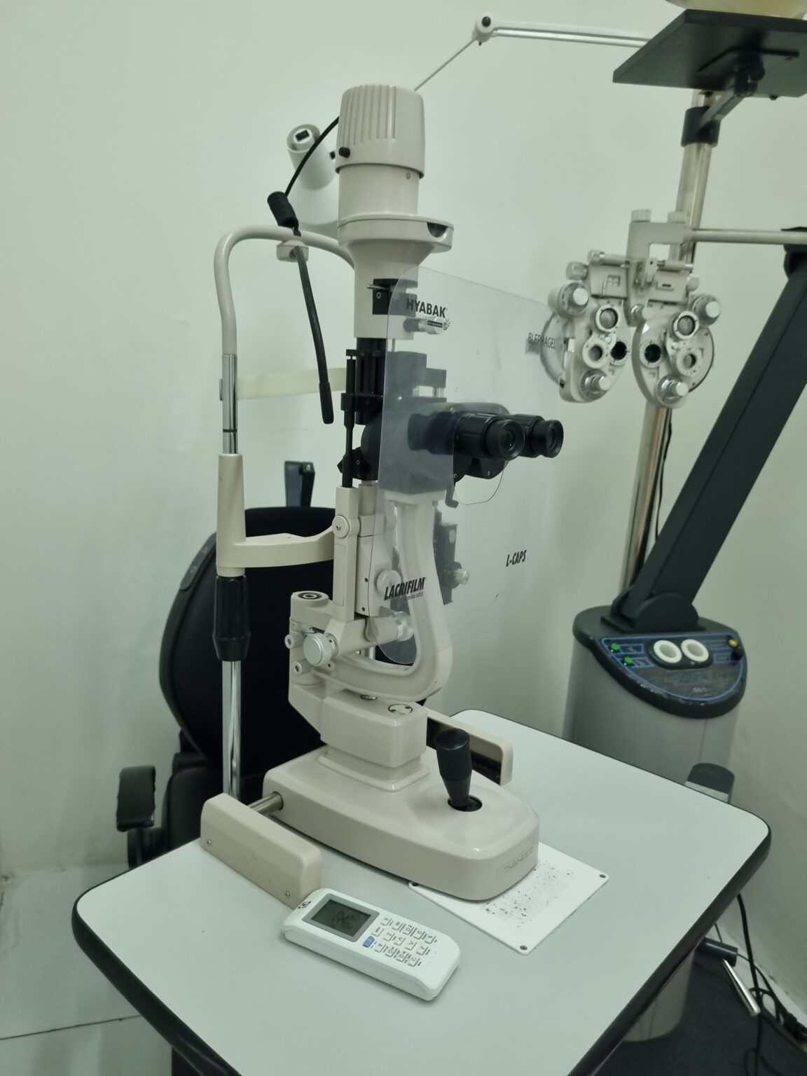 Sala de exame da Clínica Visão Prime com cadeira, refrator e lâmpada de fenda
